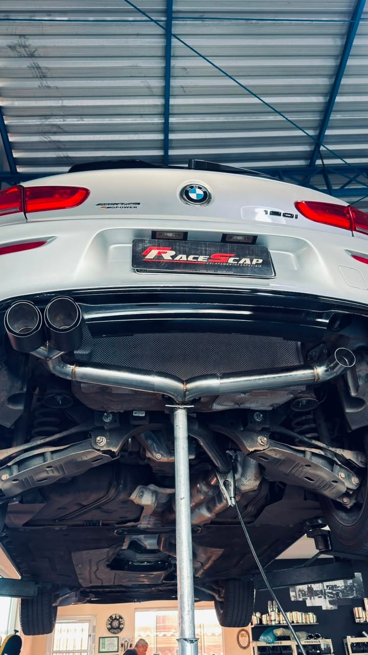 BMW 120i branca vista de baixo com sistema de escape em inox e ponteiras esportivas pretas