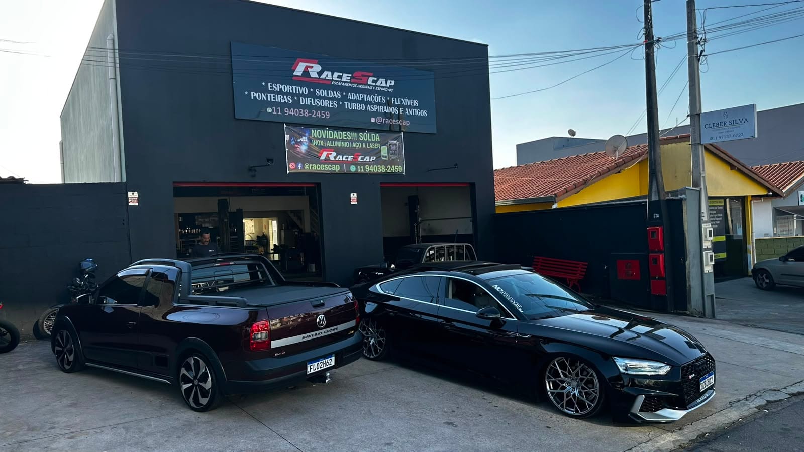Fachada da RaceScap Escapamentos na Av. Itália, em Itupeva, ao entardecer, com dois carros estacionados na frente